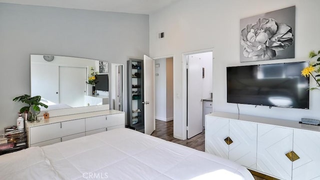 bedroom with high vaulted ceiling, dark wood-type flooring, and connected bathroom