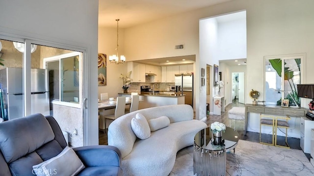 living room with a towering ceiling and a chandelier