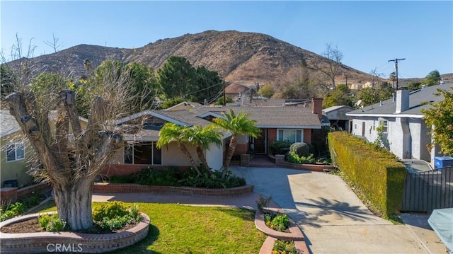 view of front of home with a mountain view and a front yard