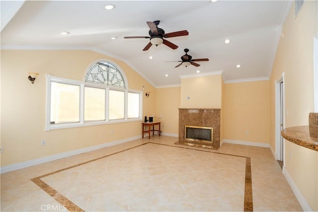 unfurnished living room with ceiling fan, vaulted ceiling, a premium fireplace, and crown molding