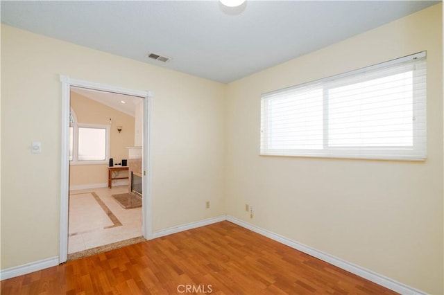 empty room with lofted ceiling and hardwood / wood-style floors