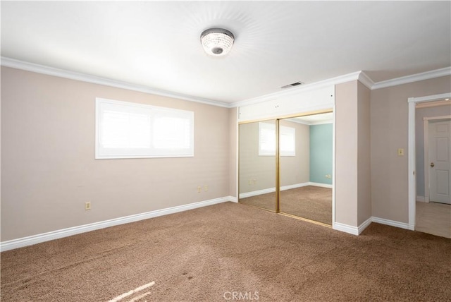 unfurnished bedroom with a closet, carpet flooring, and crown molding