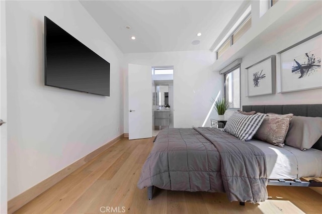 bedroom featuring ensuite bathroom and light hardwood / wood-style flooring