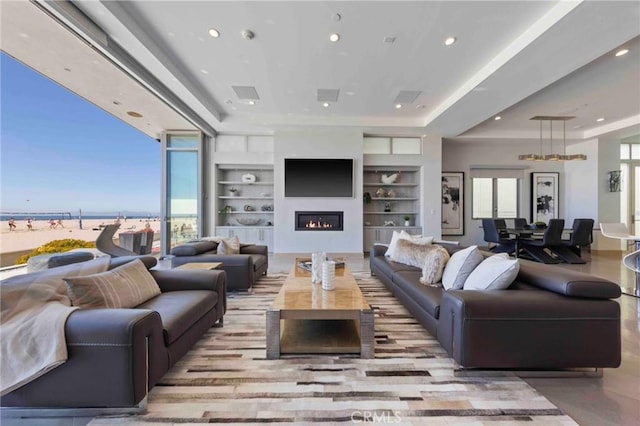 living room featuring a water view and built in shelves