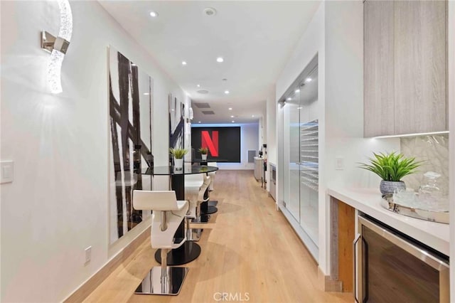 hall featuring beverage cooler and light hardwood / wood-style flooring