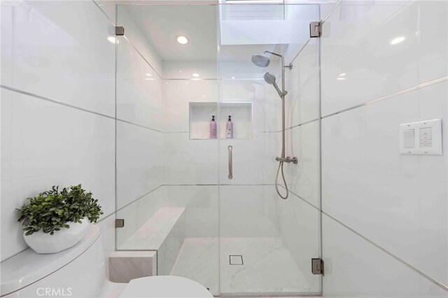 bathroom with toilet and an enclosed shower