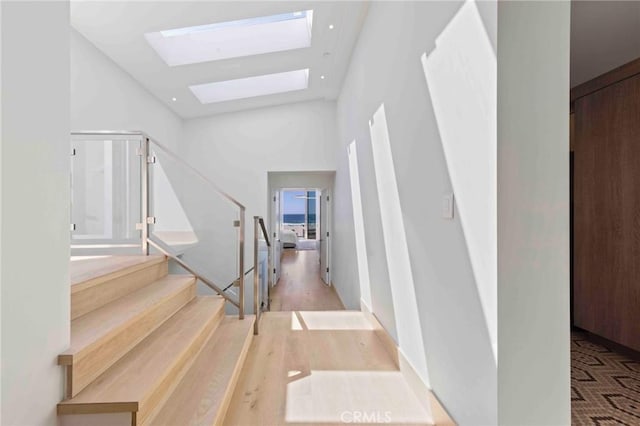 staircase with a skylight and a towering ceiling