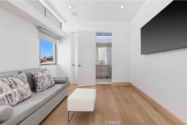 living room featuring sink and light hardwood / wood-style flooring