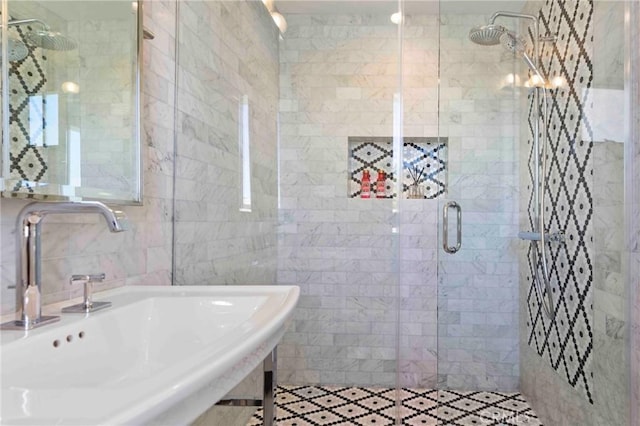 bathroom with tile walls, walk in shower, and sink