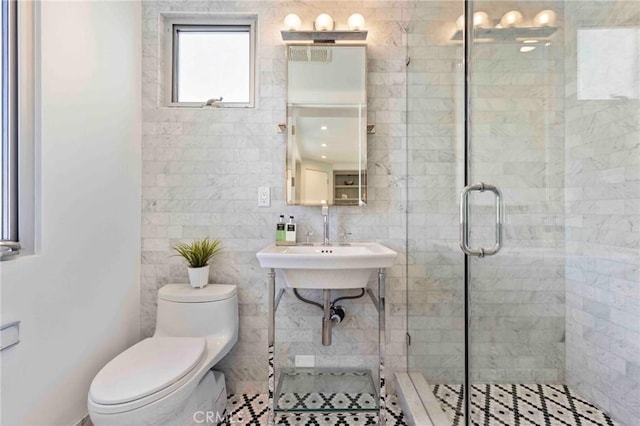 bathroom featuring sink, an enclosed shower, and toilet