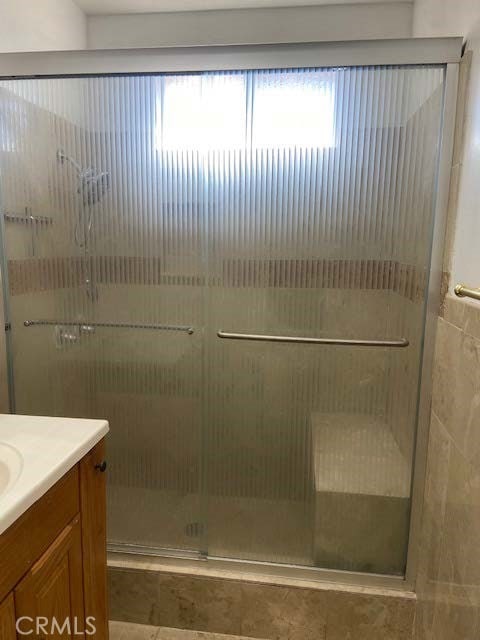 bathroom with walk in shower and vanity