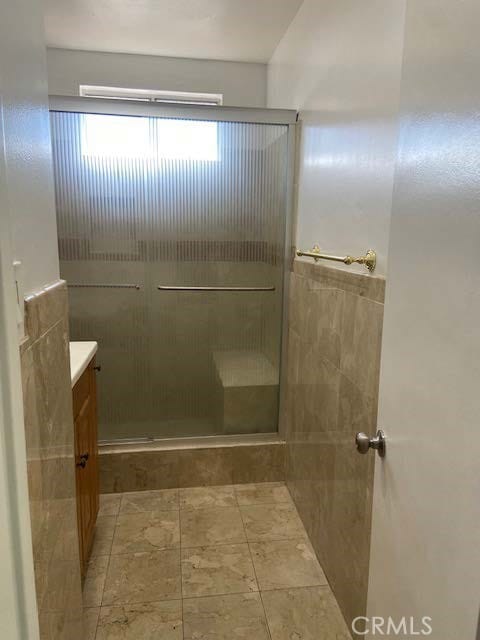 bathroom with a shower with door and vanity