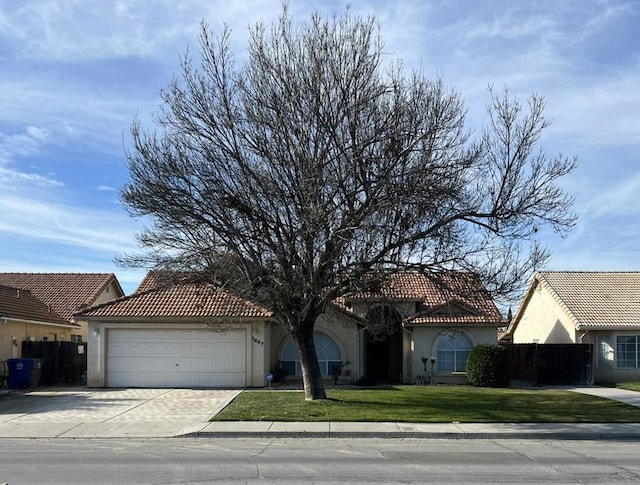 mediterranean / spanish home featuring a front yard and a garage