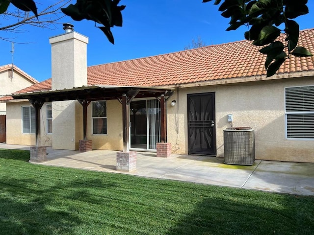 back of property with a yard, cooling unit, and a patio area