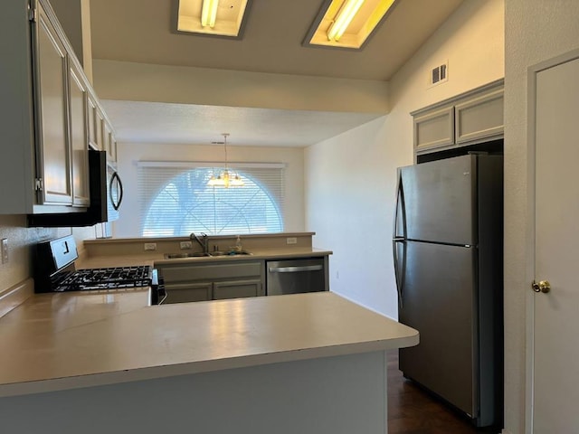 kitchen with pendant lighting, sink, gray cabinets, appliances with stainless steel finishes, and kitchen peninsula