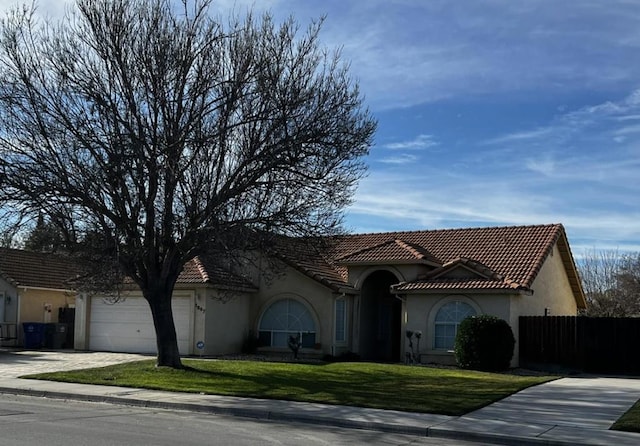 mediterranean / spanish house with a garage and a front yard