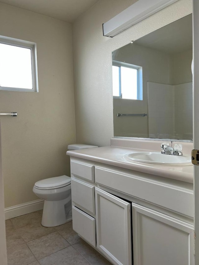 bathroom with vanity, a healthy amount of sunlight, toilet, and walk in shower