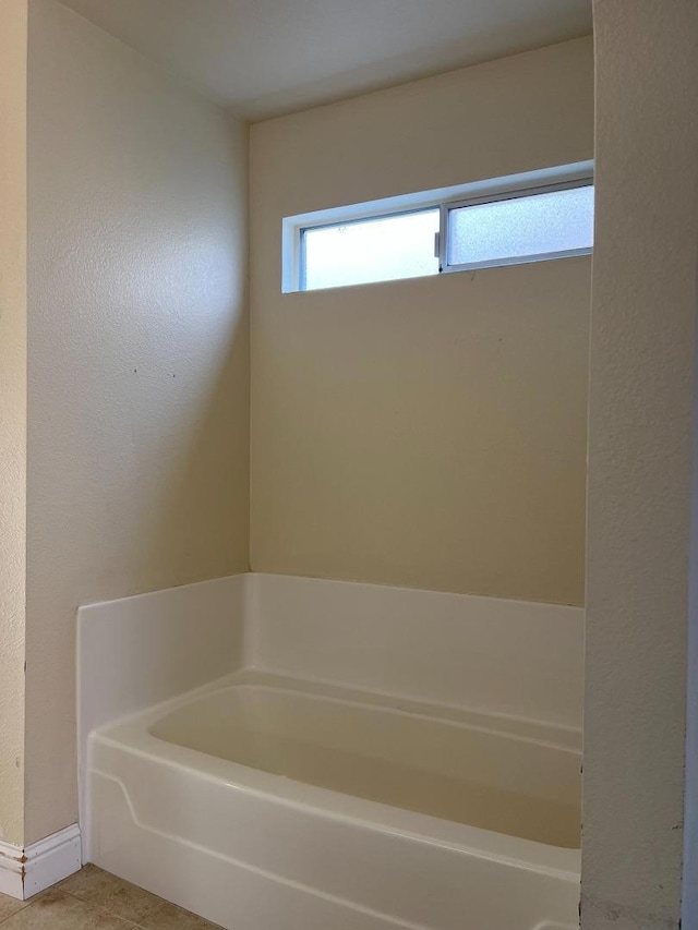 bathroom featuring tile patterned flooring and a bath