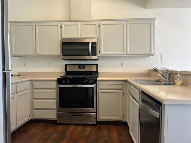 kitchen featuring dark hardwood / wood-style flooring, sink, stainless steel appliances, and white cabinets