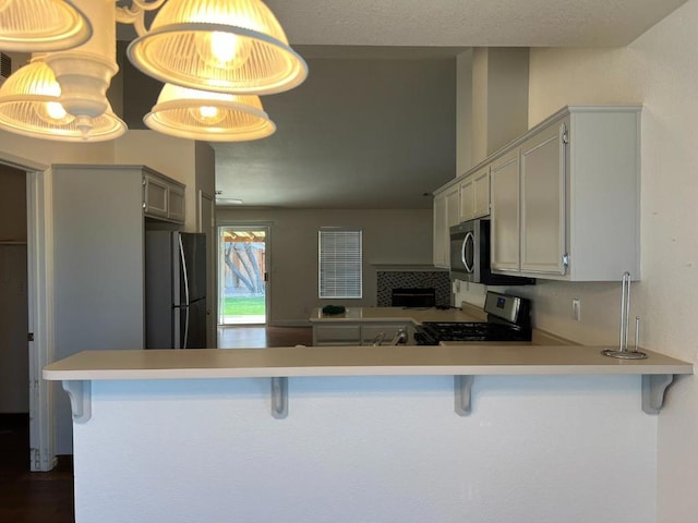 kitchen with a breakfast bar, stainless steel appliances, and kitchen peninsula