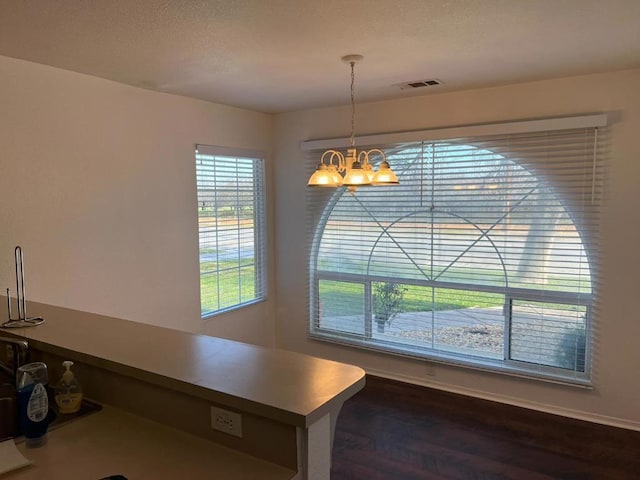 unfurnished dining area with dark hardwood / wood-style flooring and a chandelier