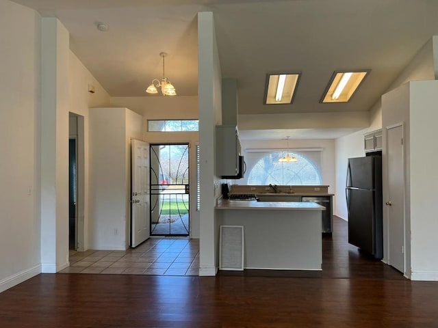 kitchen featuring black refrigerator, dark wood-type flooring, white cabinets, and kitchen peninsula