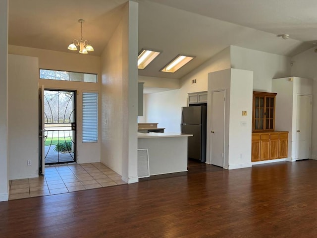 foyer featuring hardwood / wood-style flooring, high vaulted ceiling, and a chandelier