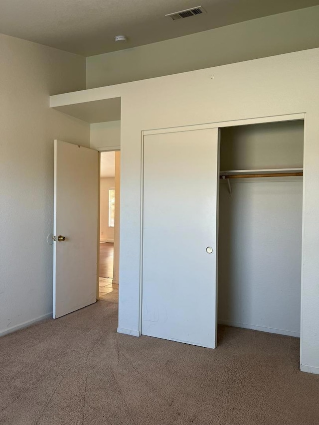 unfurnished bedroom featuring carpet floors and a closet