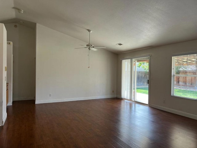 empty room with ceiling fan, lofted ceiling, and dark hardwood / wood-style floors