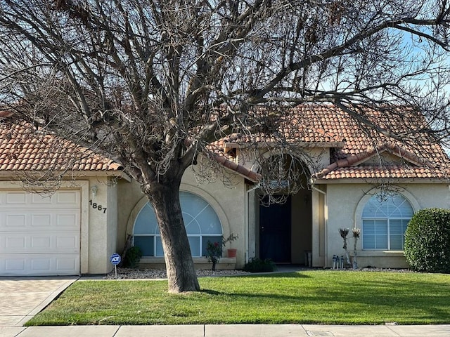 mediterranean / spanish-style home with a garage and a front yard