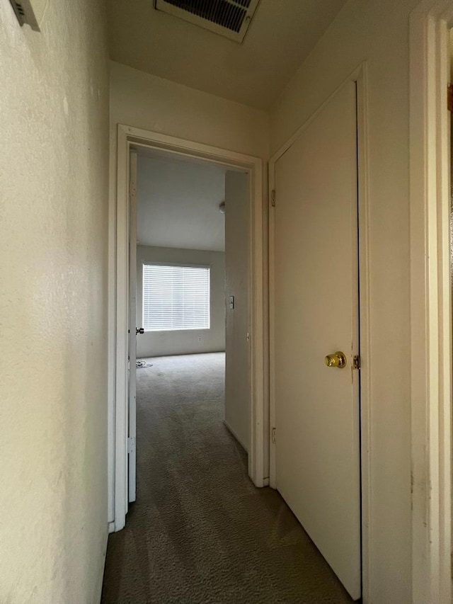 hall featuring dark colored carpet