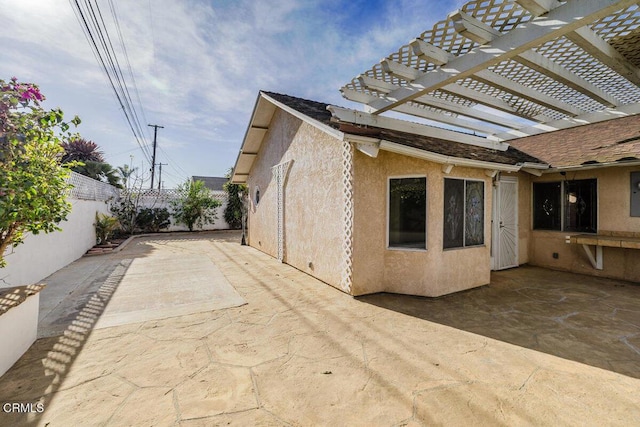 view of property exterior featuring a patio and a pergola