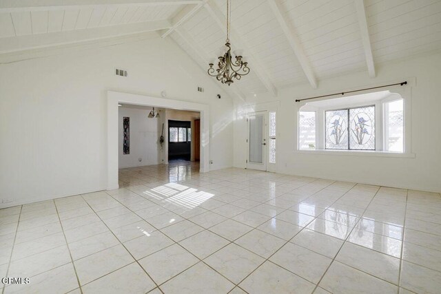 tiled empty room featuring an inviting chandelier, beam ceiling, and high vaulted ceiling