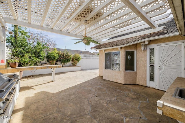 view of patio with ceiling fan, an outdoor kitchen, a pergola, and sink