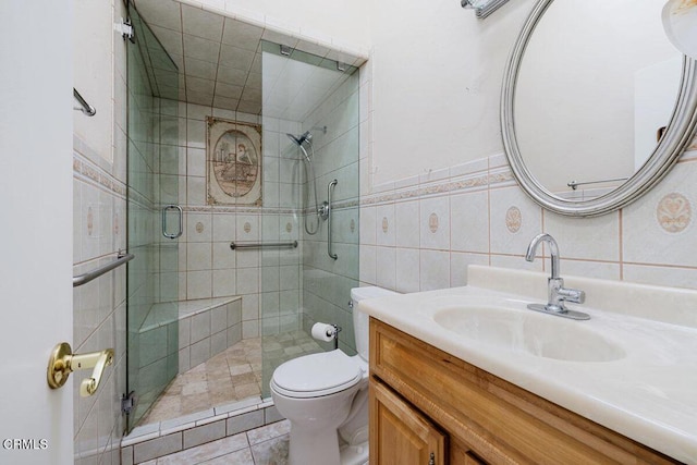 bathroom with tile patterned floors, vanity, tile walls, toilet, and walk in shower