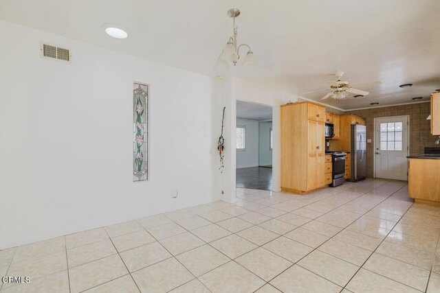 unfurnished living room featuring light tile patterned floors and ceiling fan with notable chandelier