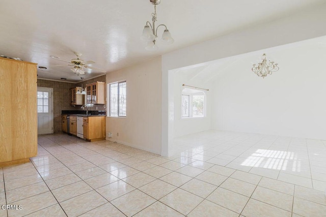 kitchen with decorative light fixtures, dishwasher, sink, light tile patterned floors, and ceiling fan with notable chandelier