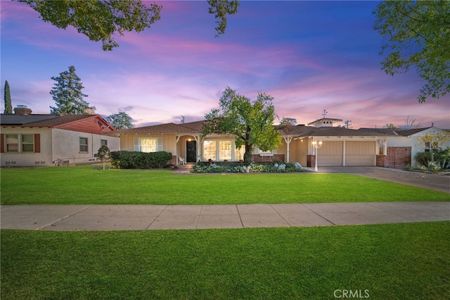 ranch-style home featuring a garage and a yard