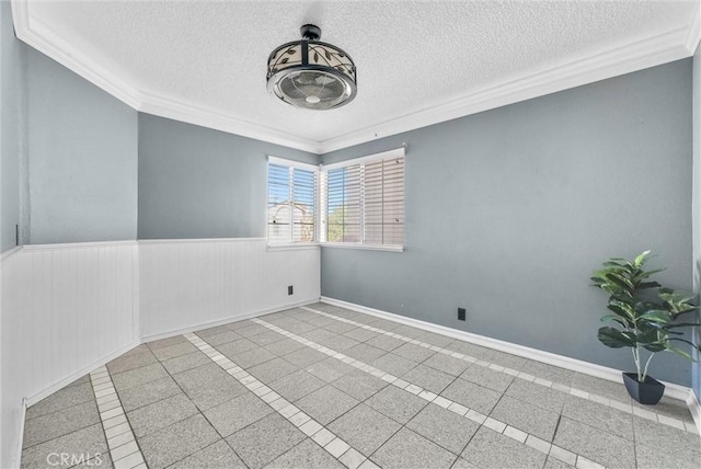 tiled spare room featuring a textured ceiling and ornamental molding