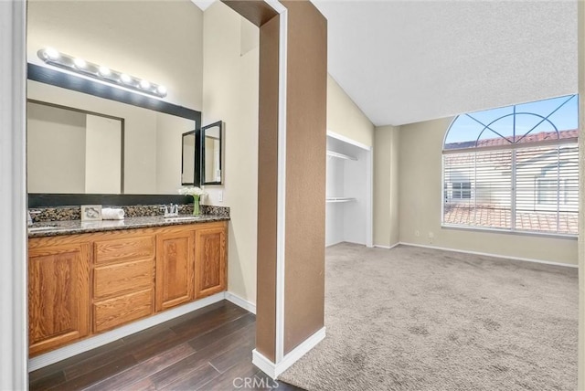 bathroom featuring vaulted ceiling, hardwood / wood-style floors, and vanity