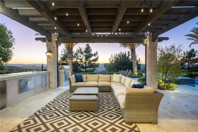 patio terrace at dusk featuring grilling area, a sink, an outdoor hangout area, and area for grilling