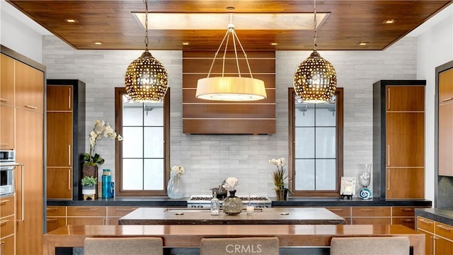 kitchen with wood ceiling, dark countertops, decorative backsplash, and an inviting chandelier