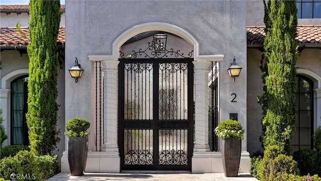 2 Thomas Rd, Ladera Ranch, CA 92694 - property entrance featuring a tile roof, stucco siding, and a gate