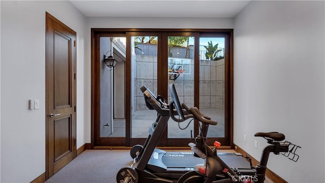 workout area with baseboards and carpet flooring
