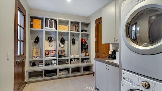washroom with stacked washer and dryer and cabinet space