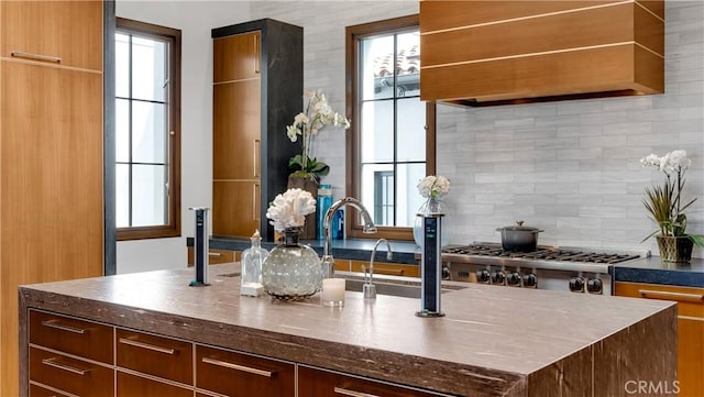 kitchen featuring tasteful backsplash, a healthy amount of sunlight, stainless steel gas cooktop, and modern cabinets