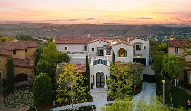mediterranean / spanish house with stucco siding, a balcony, and a mountain view