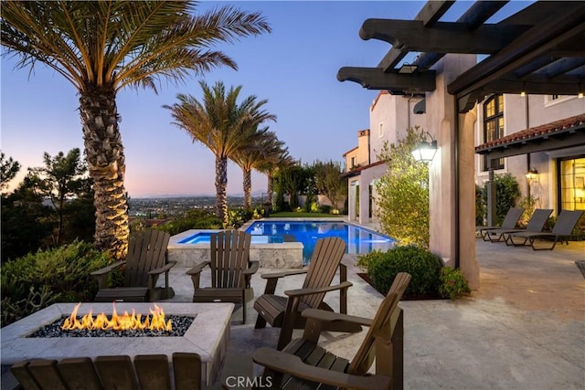 pool with a fire pit and a patio