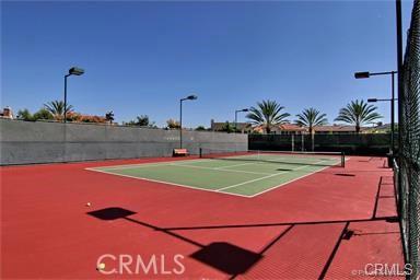 view of tennis court with community basketball court and fence
