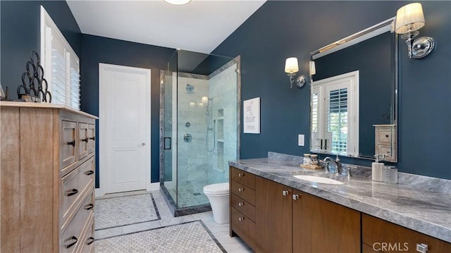 bathroom with walk in shower, tile patterned floors, vanity, and toilet